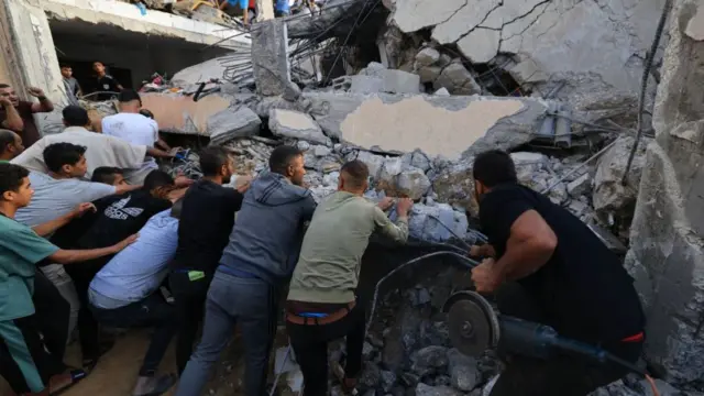 Lots of people pushing up on concrete from a fallen building