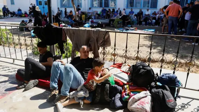 People recline outside a warehouse