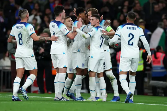 England players celebrate with Harry Kane after his goal.