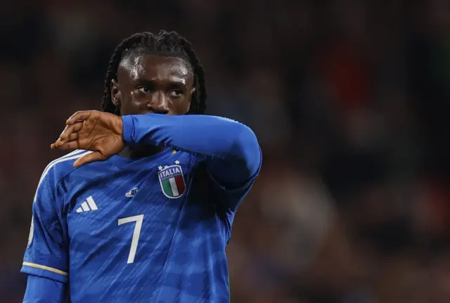 Moise Kean wipes the sweat off his face.