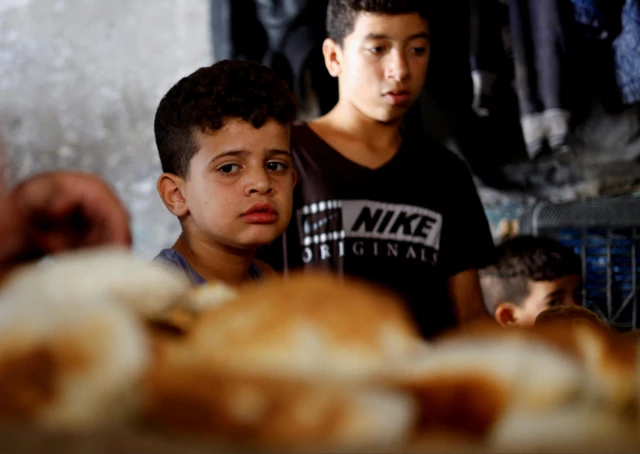 Palestinian child looks at bread in Khan Yunis