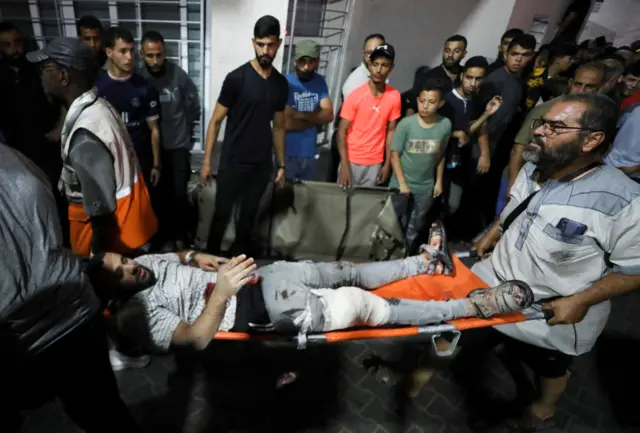 An injured person is assisted at Shifa Hospital after an Israeli air strik