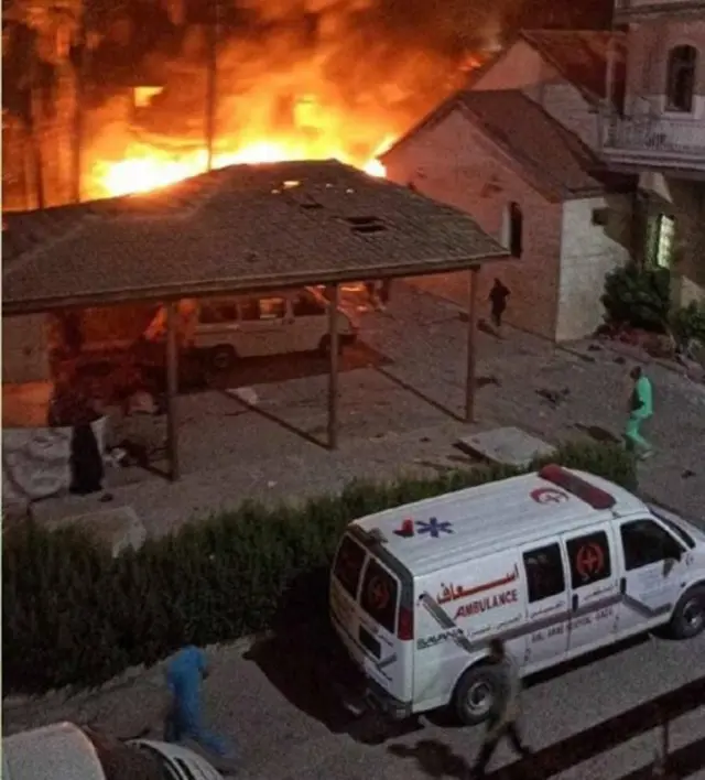 A fire burns at the site of an alleged hospital strike in Gaza