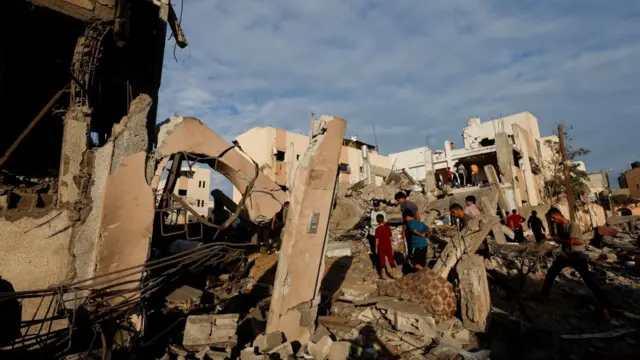 People searching through the rubble of buildings