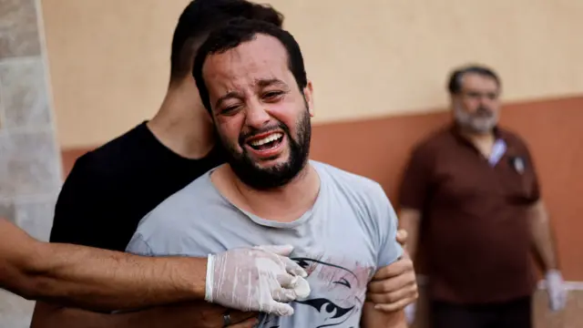 A mourner reacts as bodies of Palestinians killed in Israeli strikes lie at a hospital in Khan Younis in the southern Gaza Strip, October 17, 2023.