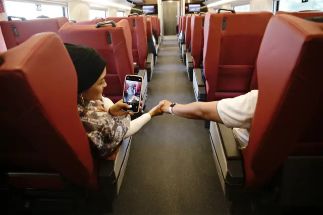 Couple holds hands inside Whoosh high speed train in Indonesia