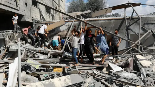 Palestinians search for casualties at the site of Israeli strikes on houses in Rafah in the southern Gaza Strip