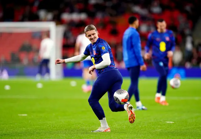 Gallagher juggles a ball during the warm up at Wembley.