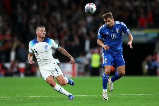 Barella heads the ball away ahead of Phillips.