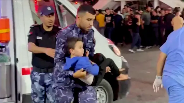 An injured child is carried into hospital