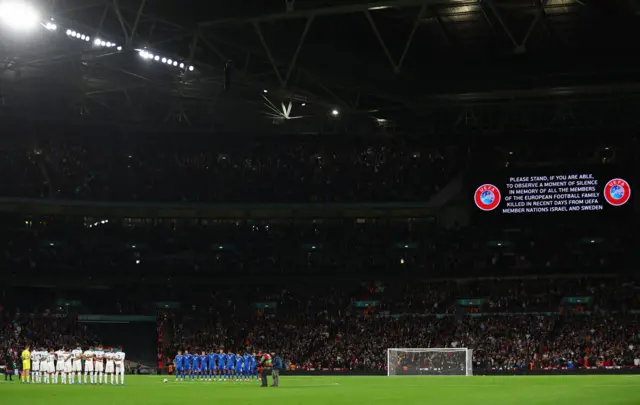 A moments silence is observed by players on the pitch.