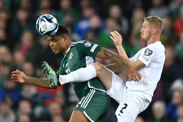 Josh Magennis heads the ball