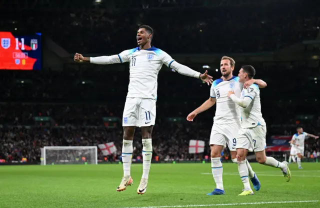 Rashford jumps in the air in celebration as Kane and Foden follow.