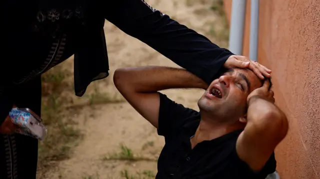 Mourners react next to the bodies of Palestinians killed in Israeli strikes, at a hospital in Khan Younis in the southern Gaza Strip, October 17, 2023.