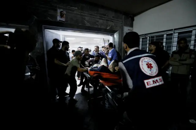 An injured man being assisted at the Shifa Hospital