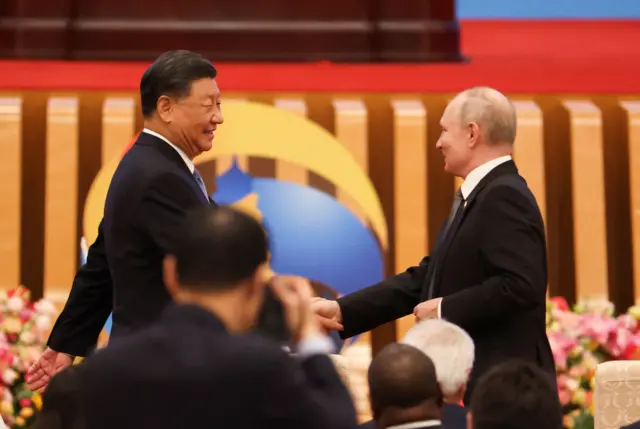 Presidents Xi and Putin shake hands