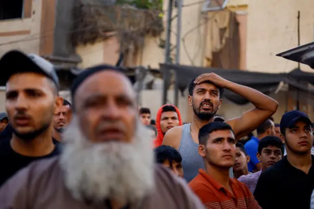 Palestinians react at the site of deadly Israeli strikes