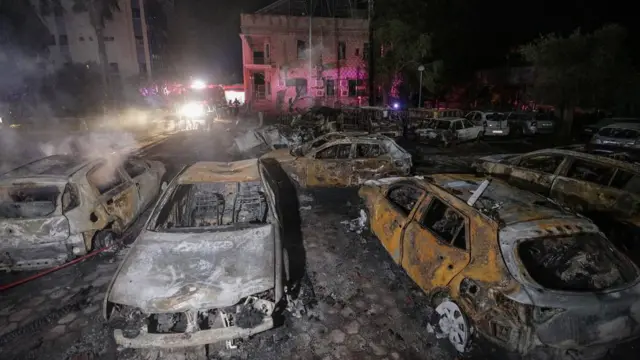 Burnt out cars are seen outside the hospital