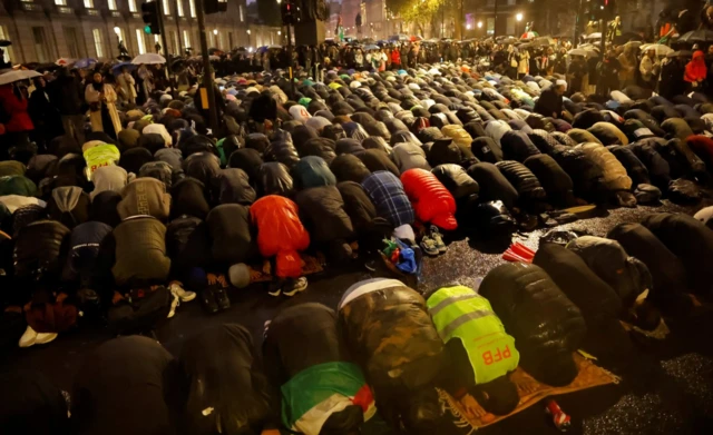 Demonstrators participate in Muslim prayers during a vigil outside Downing Street in solidarity with Palestinians after the Al-Ahli hospital blast in Gaza