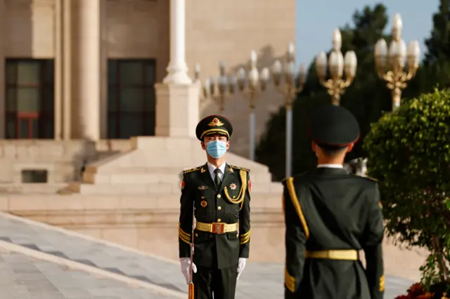 Honour guards standing outside the Great Hall of the People in Beijing as international delegates stream in