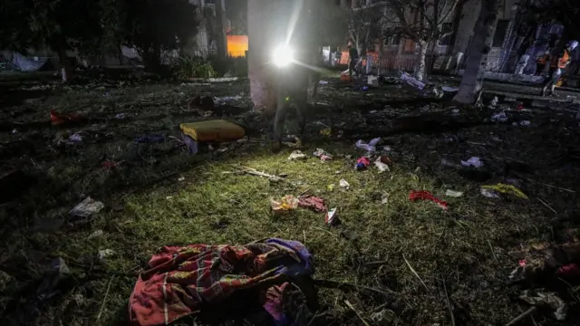 People's belongings, including clothing, strewn over the lawn in front of the hospital