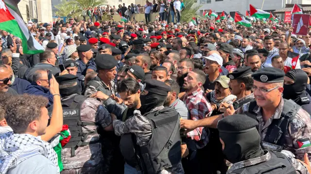 Protesters clash with security forces as they attempt to reach the Israeli embassy in Amman, Jordan