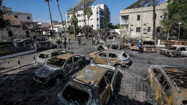 Cars parked outside Al Ahli hospital, in Gaza, are burnt after a blast on Tuesday night