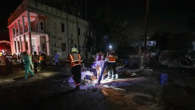 Emergency services search the rubble outside hospital for people