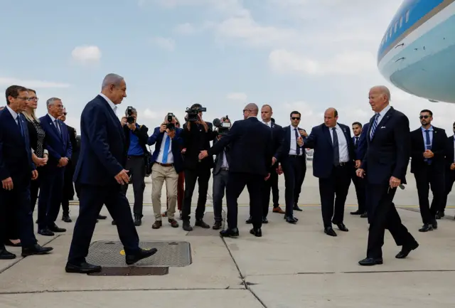 Benjamin Netanyahu and Joe Biden walk towards each other after Biden stepped off Air Force One