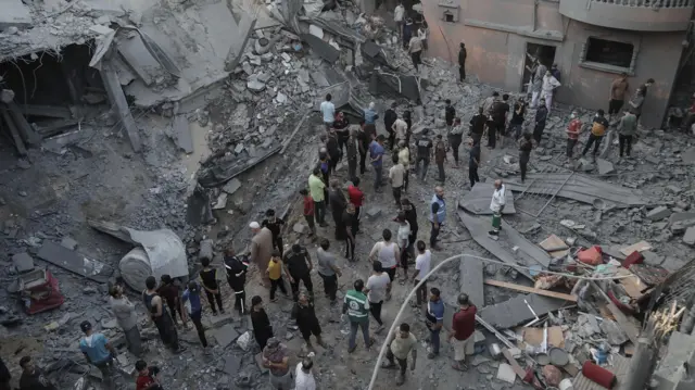 Palestinians search through rubble in Khan Younis, southern Gaza