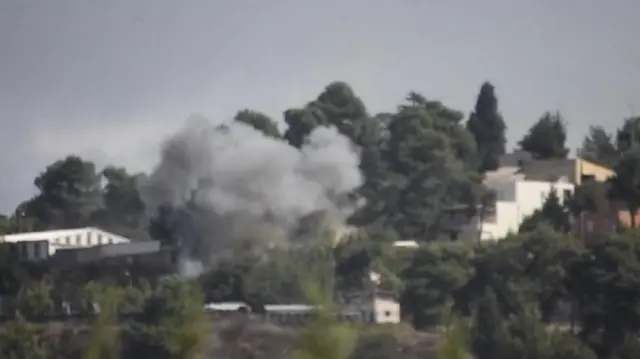 Photo shows smoke billowing from the kibbutz Manara after a strike