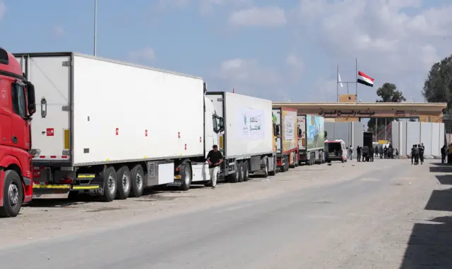 Trucks of a humanitarian aid convoy are parked outside the border gate between Egypt and Gaza, in Rafah, Egypt