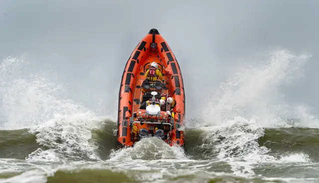 A lifeboat almost vertical as it goes headfirst into a wave