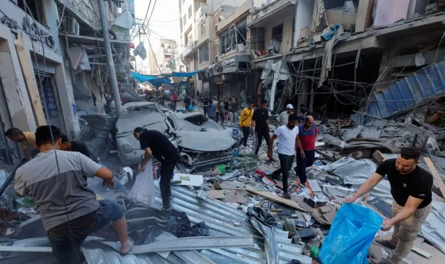 Palestinians work amidst the rubble at the site of an Israeli strike, amid the ongoing conflict between Israel and Palestinian Islamist group Hamas, in Khan Younis in the southern Gaza Strip, October 19, 2023