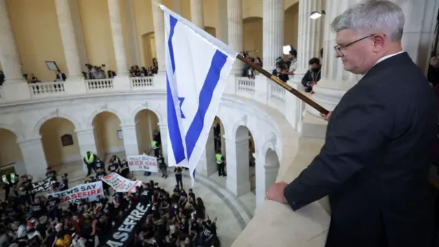 One Republican congressman was seen silently holding an Israeli flag over the group