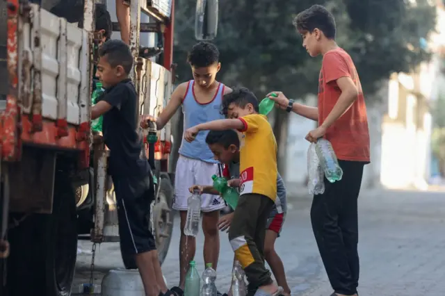 Boys refilling their bottles at a mobile cistern