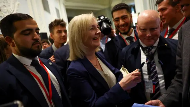 Liz Truss surrounded by journalists and camera crews ahead of her address