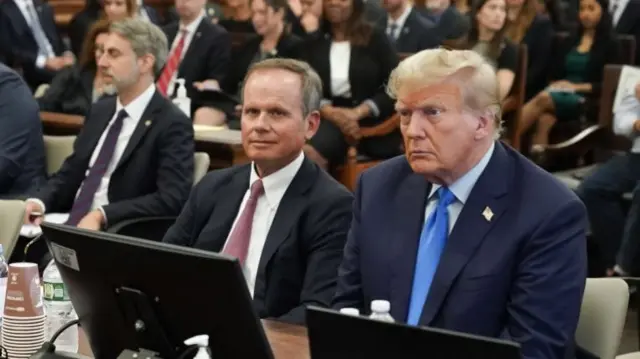 Former US President Donald J. Trump (R) sits with his attorney Christopher Kise (L) in the courtroom in New York