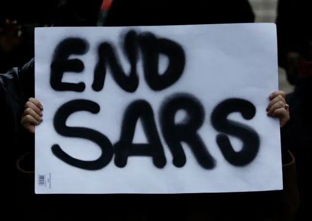 A woman holds an "End Sars" sign in London, in October 2020.