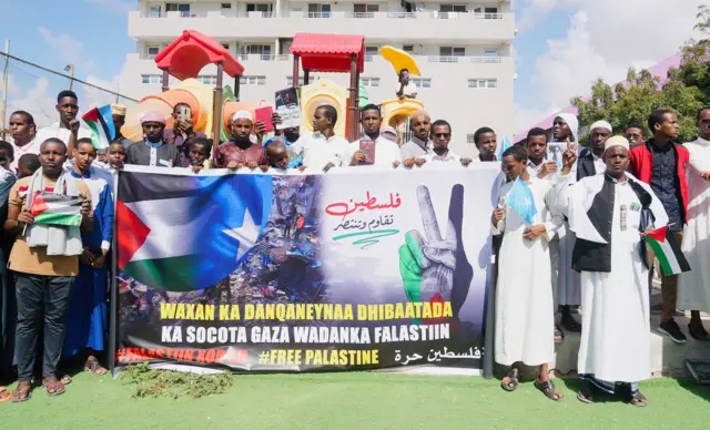 Men and boys standing next to a banner at the protest.