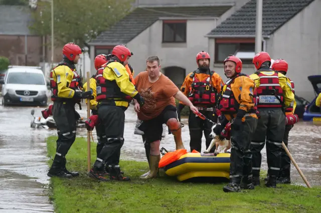 Members of the emergency services help local residents to safety in Brechin as Storm Babet batters the country.