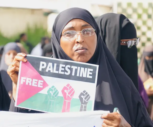 A woman holding a 'Free Palestine' banner at the protest.