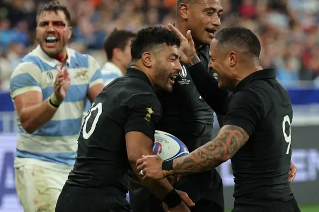 New Zealand's blindside flanker Shannon Frizell (C) celebrates with New Zealand's fly-half Richie Mo'unga and New Zealand's scrum-half Aaron Smith