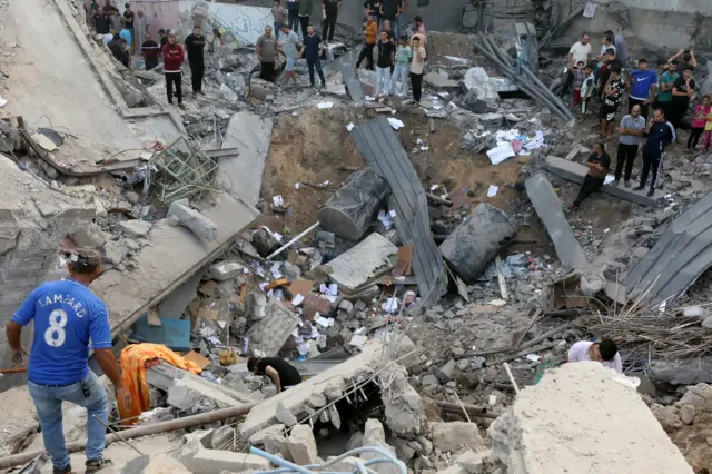 Palestinians search the destroyed annex of the Greek Orthodox Saint Porphyrius Church, the oldest church still in use in Gaza, on 20 October