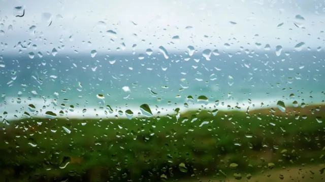 Rain on a window looking out to sea