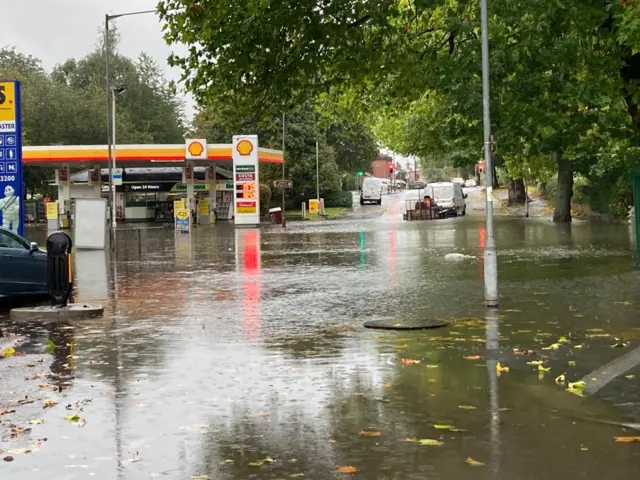 Water covering a street outside a petrol station