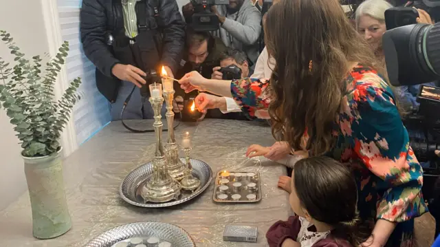 Candles are lit at a vigil held in Evanston, the hometown of freed hostages Judith and Natalie Raanan.