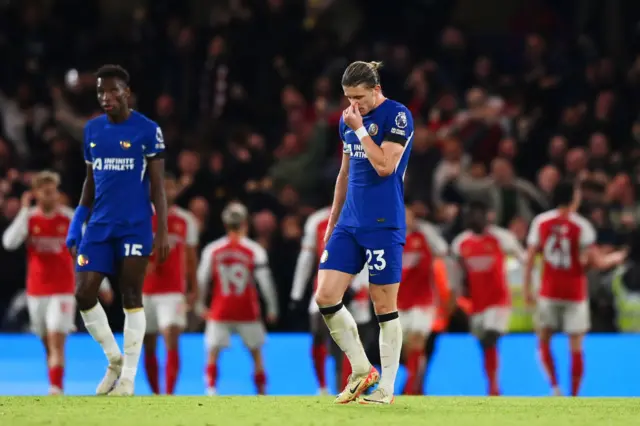 Gallagher and Jackson stand stunned as Arsenal celebrate with their fans in the background.