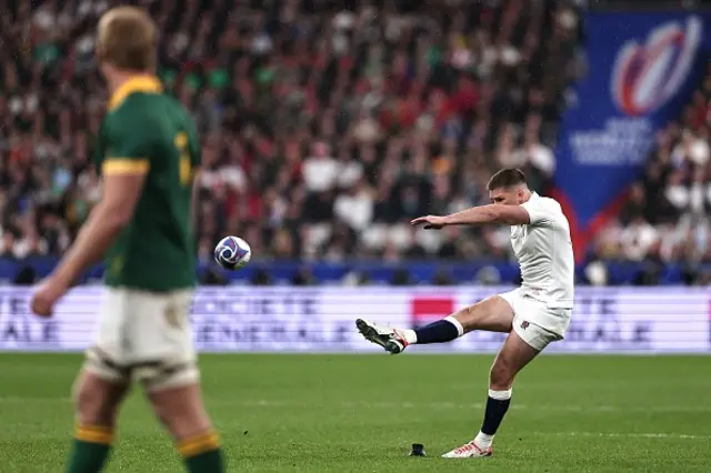 England's fly-half and captain Owen Farrell kicks the ball