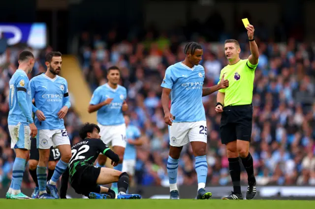 Manuel Akanji of Manchester City receives a yellow card